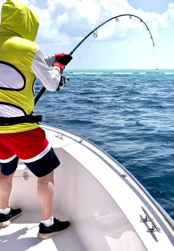 Angler fighting a Giant Trevally near the reefs edge.